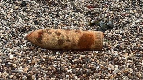 A shell on shingle, the shell is rusty 