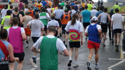 Marathon runners head past the river Thames 