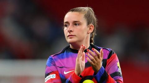 Ella Toone claps her hands while wearing the England uniform