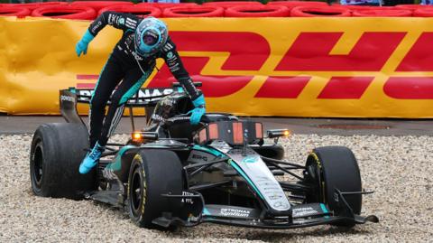 George Russell jumps out of his Mercedes after a collision with Ferrari's Lewis Hamilton forced his retirement from the Belgian Grand Prix