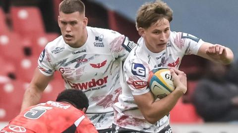 Scarlets wing Ellis Mee, who was capped by Wales in the 2025 Six Nations, attacks the Lions defence.