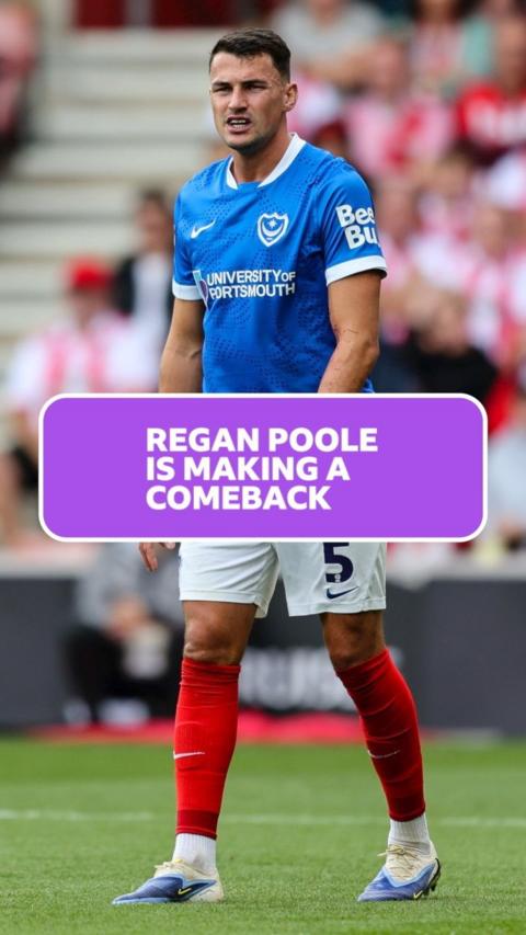 Regan Poole wears a blue Portsmouth FC kit and is walking on the pitch