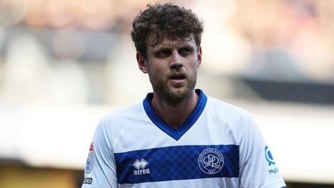 Nicolas Madsen in blue and white hooped QPR shirt