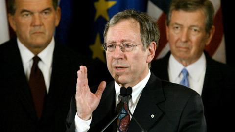 A photo of Mr Cotler from 2004, showing him speaking at a podium during a G8 ministerial news conference in Washington, DC. He has short, grey hair and wears glasses.