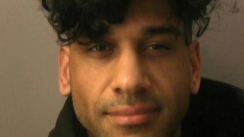 A custody image of Inam Khan.