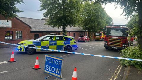 A police car and two fire engines behind a police cordon