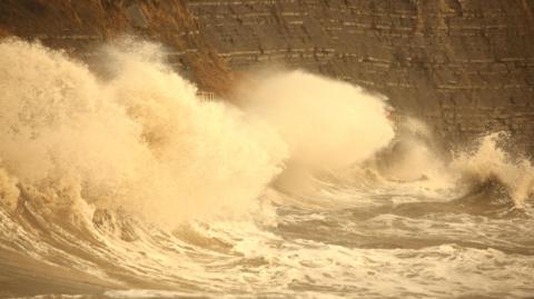 Large waves break against Church Cliff Walkway, East Cliffs, Lyme Regis