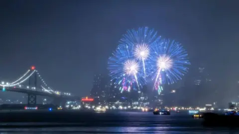 Fireworks light up the San Francisco Bay above the city skyline as seen from Treasure Island in San Francisco