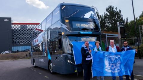 A picture showing a grey bus with CBS Arena written as the destination outside Coventry railway station.