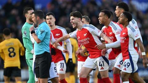 Arsenal's players protest at referee Michael Oliver after a red card to Myles Lewis-Skelly