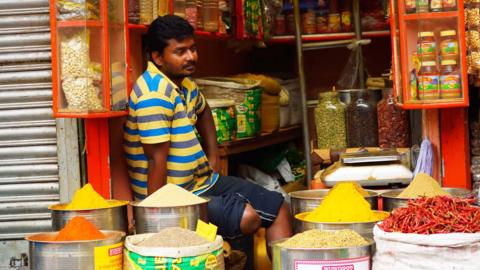 Kolkata, India - March 26, 2017: A shopkeeper selling different types of Indian spices in his shop.