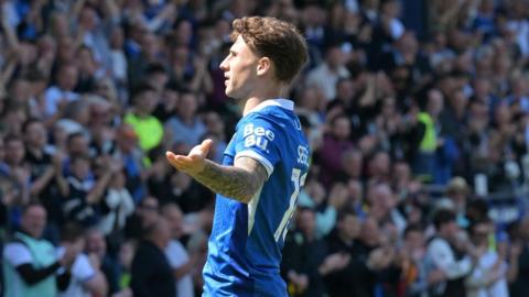 Adrian Segecic celebrates with arms spread wide in front of Portsmouth fans