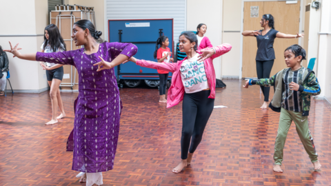 A group of people are dancing and in a studio