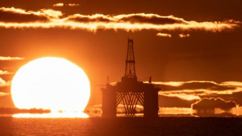 The sun rising behind a redundant oil platform moored in the Firth of Forth near Kirkcaldy, Fife