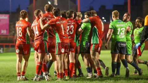 Keighley Cougars v Sheffield Eagles - Pre Season Friendly 2025 - there are a group of rugby players on a pitch, some in red kits and some in green.
