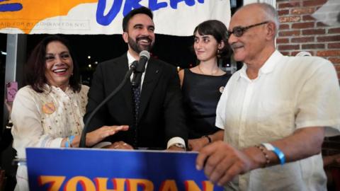 Zohran Mamdani reacts next to his parents Mahmood Mamdani and Mira Nair and wife Rama Duwaji during a watch party for his primary election