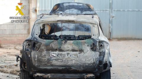 A police photograph of a torched car.