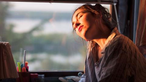 A woman basking her face in sunshine