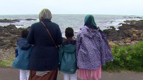 Ms Ali and her children looking out to school