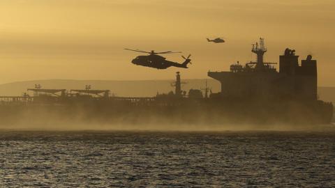 A helicopter in the sky above a seized tanker in the English Channel 