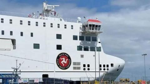 The bow of the Manxman, a white box like ship with the three legs of man and the Isle of Man Steam Packet Company written around it.