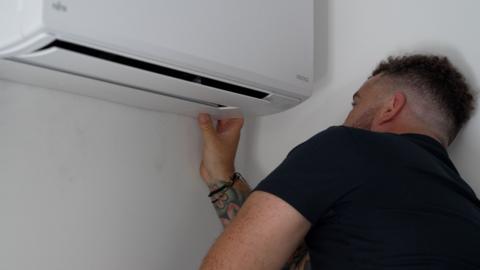 An air conditioning unit being installed on a wall.
