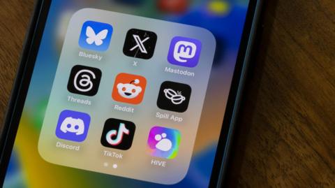 An iPhone with a number of social media apps showing on the screen