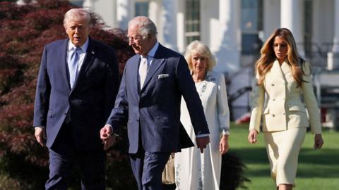 The Queen, King, Donald and Melania Trump converse as they walk outside the White House through the garden on Monday.