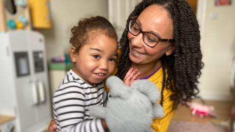 Rachel with two-year-old daughter Winnie holding a toy rabbit