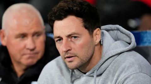 West Brom boss Ryan Mason sits in the dugout