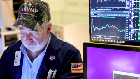 A trader wears a hat in support of Republican Donald Trump, after he won the US presidential election, at the New York Stock Exchange in New York City, US, on 6 November 2024.