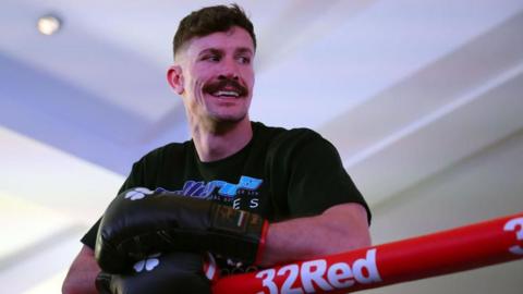 Nathan Heaney takes a break and leans on the ropes during a training session