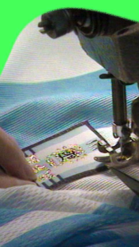 A close up of a 1998 Argentina shirt having a badge stitched to it using a sewing machine.