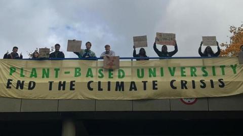 Students holding placards and a banner