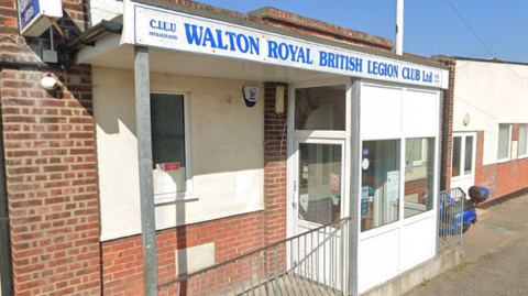 Outside the Walton Royal British Legion Club's office in Walton-on-the-Naze. There is a white sign above the door with the organisation's name in blue lettering.