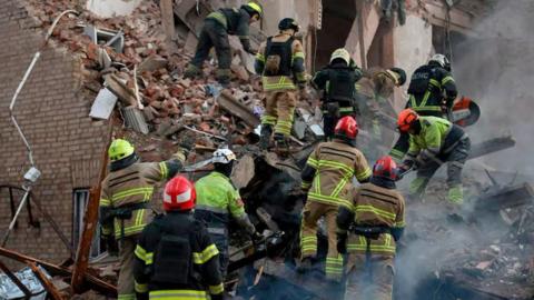 Rescue workers searching the ruins of a collapsed building in Ukraine