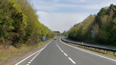 Google maps street view of the A303 in Wiltshire. The road is long and there are trees either side of it.
