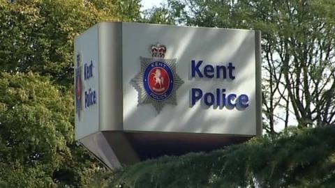 A white sign with "Kent Police" written on it