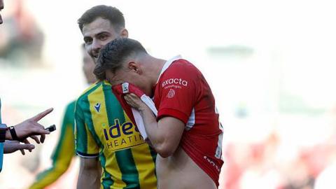 Scott Twine covers his face with his shirt during Bristol City's defeat to West Bromwich Albion