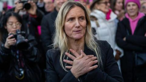 Kim Leadbeater stands with her hands across her chest as she reacts to meeting supporters of her assisted dying bill