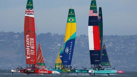 The Great Britain SailGP team race against the Brazil SailGP team and the United States SailGP team on the water