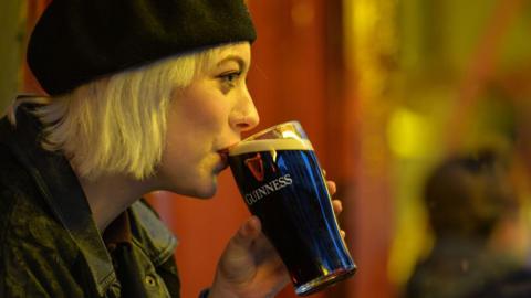 Woman drinks pint of Guinness