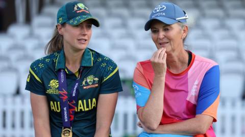 Nicola Carey, left, with a medal round her neck talks to Charlotte Edwards