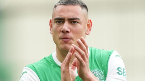 Lewis Miller applauds the Hibernian supporters