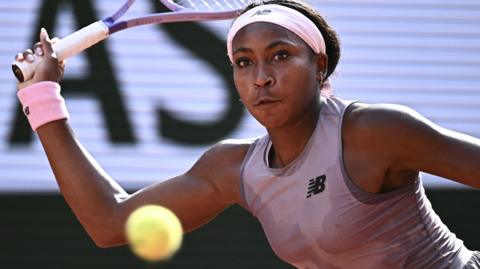 Coco Gauff looks at the ball and prepares to hit a forehand