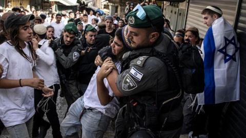 Israeli police remove a right-wing activist in Jerusalem's Old City from a crowd during the Jerusalem Day march, 