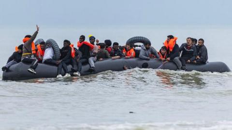 Migrants crowd a smuggler's inflatable dinghy in an attempt to cross the English Channel, after leaving Ecault beach in Saint-Etienne-au-Mont, near Neufchatel-Hardelot, northern France on October 30, 2024