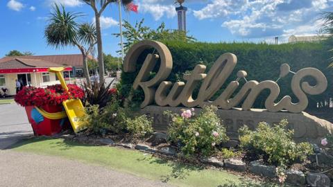 Entrance to the Butlin's Skegness site. The company's name is spelt out in a large stone sculpture surrounded by flowers