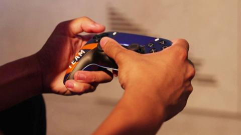 Someone holds a games controller.