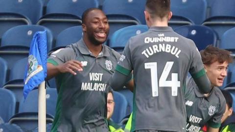 Yakou Meite (left) celebrates scoring for Cardiff